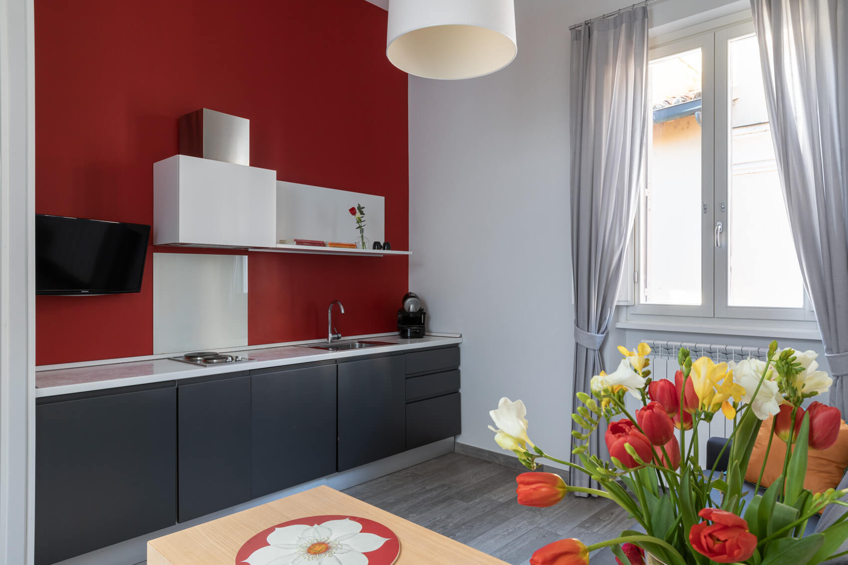 Zona giorno con cucina integrata nell’Appartamento Alioth Now Apartments