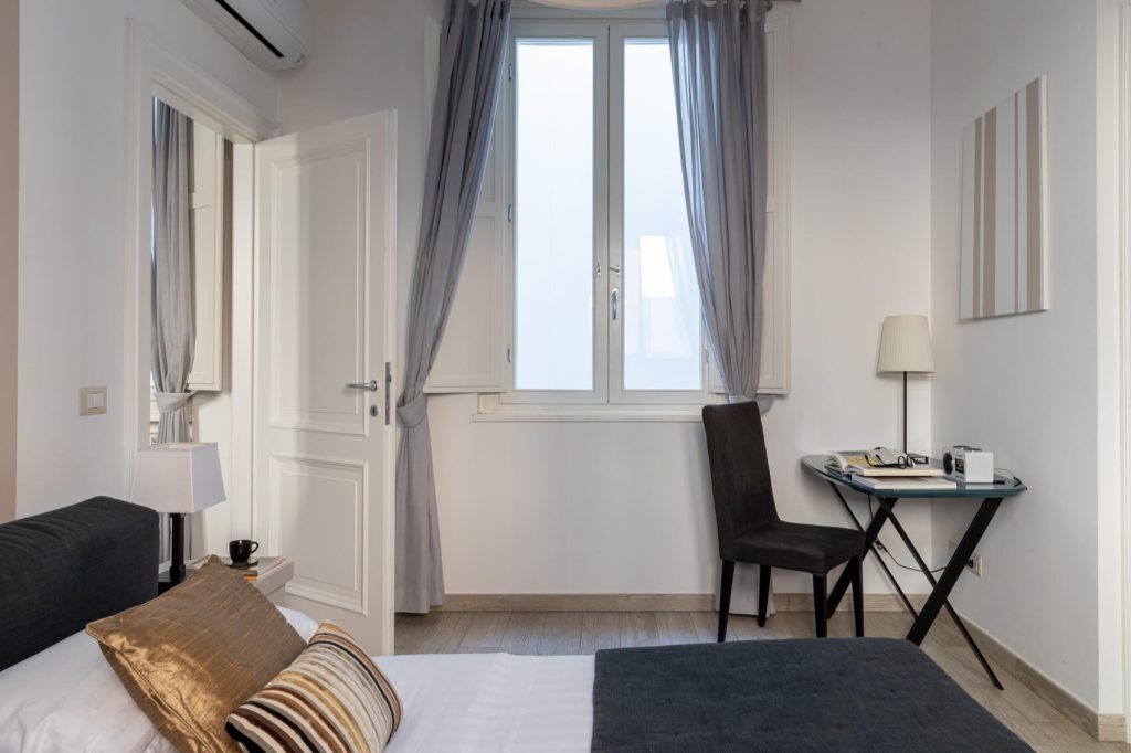 Letto matrimoniale e arredi curati nella camera dell’Appartamento Parbleu