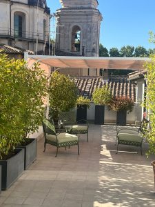 Terrazza Now Apartments allestita con tavolini per momenti conviviali