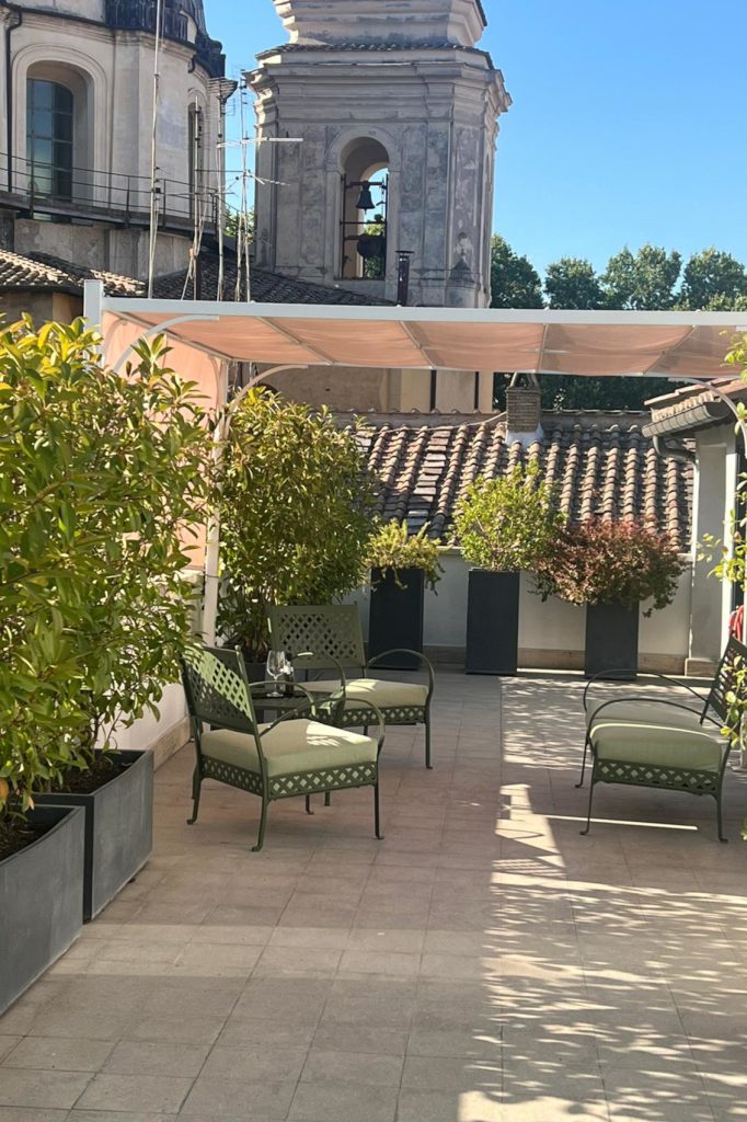 Terrazza di Now Apartments con piante, tavolini e poltroncine a Roma centro