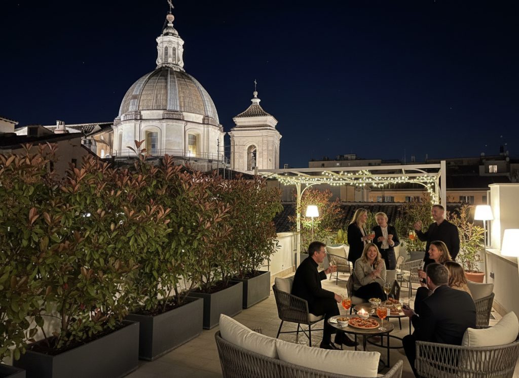 Aperitivo serale sulla terrazza di Now Apartments con persone sedute ai tavoli durante un evento