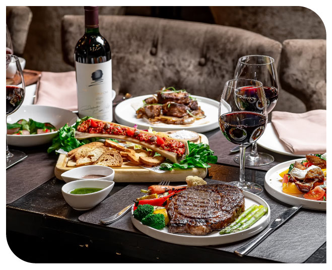 Tavola imbandita con cibo, bottiglie di vino e calici in vetro